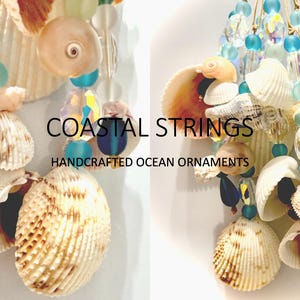 May include: A decorative hanging ornament featuring strings of white seashells, translucent blue beads, and clear faceted crystals. The text COASTAL STRINGS HANDCRAFTED OCEAN ORNAMENTS is centered between two clusters of these shell and bead strands.