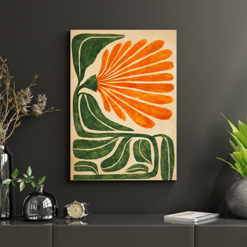 May include: Abstract floral art print featuring a large orange flower with green leaves and stems against a beige background. The artwork is mounted on a wooden panel and displayed on a dark gray wall. The style is reminiscent of mid-century modern art.