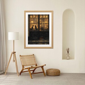 May include: A framed print depicts a cozy scene of a couple in a warmly lit cafe. The artwork, in a wooden frame, features a dark door and windows with soft, golden light, creating a romantic ambiance. The print is displayed in a neutral-toned room.