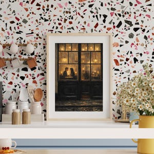 May include: A framed print depicts a romantic scene of a couple dining in a warmly lit restaurant. The artwork features a dark wooden door and window frame, with soft lighting and a cozy atmosphere. The background has a colorful terrazzo pattern.