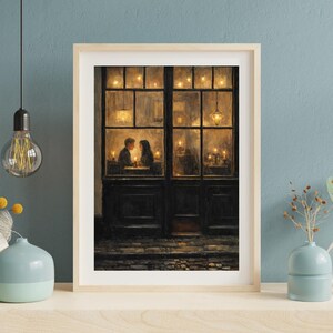 May include: A framed art print depicts a romantic scene of a couple dining by candlelight in a restaurant. The artwork features warm tones, with soft lighting illuminating the couple and the interior. The frame is a light wood color.