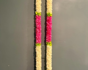 May include: Two long, vertical floral garlands featuring alternating segments of white and bright pink petals. Each segment is separated by small, vibrant lime green accents. The bottom ends of the garlands terminate in clusters of pink flowers.