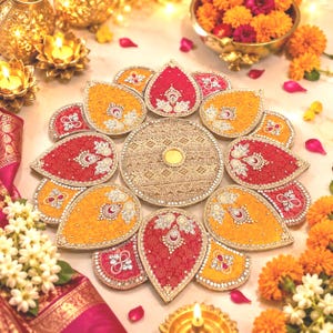 May include: A decorative circular centerpiece featuring a central gold disc surrounded by alternating red and yellow petal-shaped segments. Each segment is embellished with intricate silver beadwork, sequins, and floral patterns in a radial arrangement.