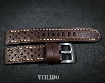 May include: Brown leather watch strap with white stitching and a silver buckle. The strap has a perforated design and the word "VERADO" is visible at the bottom. The watch band is a rich brown color.