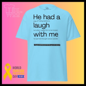 May include: Pale blue t-shirt with black text. The text reads "He had a laugh" and "with me". The shirt also has the text "If you can read between the lines, you can save a life". The shirt is for World Suicide Prevention Day.