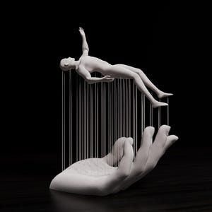 May include: A white sculpture of a human figure suspended above a large hand, connected by vertical lines. The figure is in a floating pose, with one arm raised. The hand is open, as if supporting the figure. The background is black.
