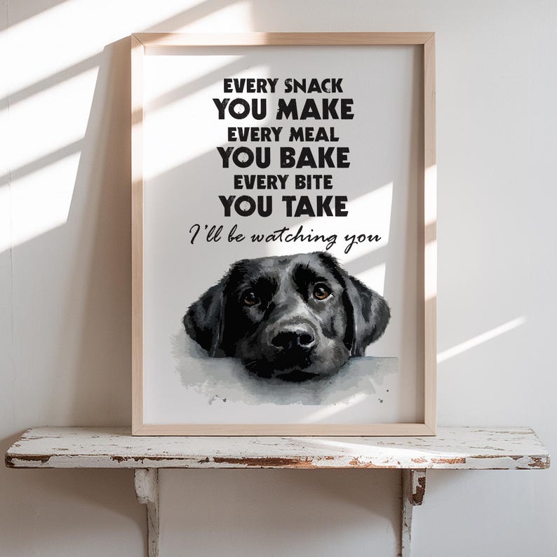 May include: Framed art print featuring a black Labrador Retriever with the text "EVERY SNACK YOU MAKE, EVERY MEAL YOU BAKE, EVERY BITE YOU TAKE, I'll be watching you." The print is in a light wood frame.