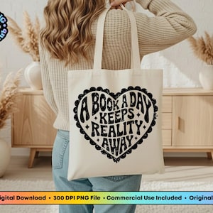 Pode incluir: Uma sacola creme com um design preto em forma de cora&ccedil;&atilde;o que diz "A Book A Day Keeps Reality Away". A sacola &eacute; segurada por uma pessoa. O logotipo PNG Bookclub est&aacute; no canto superior esquerdo.