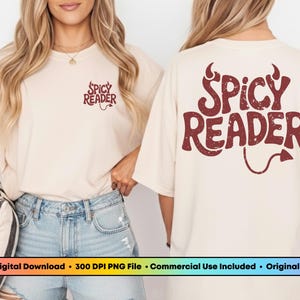 May include: Cream-colored t-shirt with the text "Spicy Reader" in maroon on the front and back. The design includes devil horns and a tail. The shirt is worn with denim shorts.