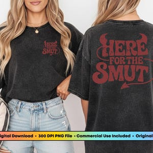 Może przedstawiać: Czarna koszulka z napisem "HERE FOR THE SMUT" w kolorze czerwonym, z motywem rog&oacute;w i ogona diabła. Prz&oacute;d koszulki ma napis "HERE FOR THE SMUT" w kolorze czerwonym. Koszulka jest noszona przez osobę.