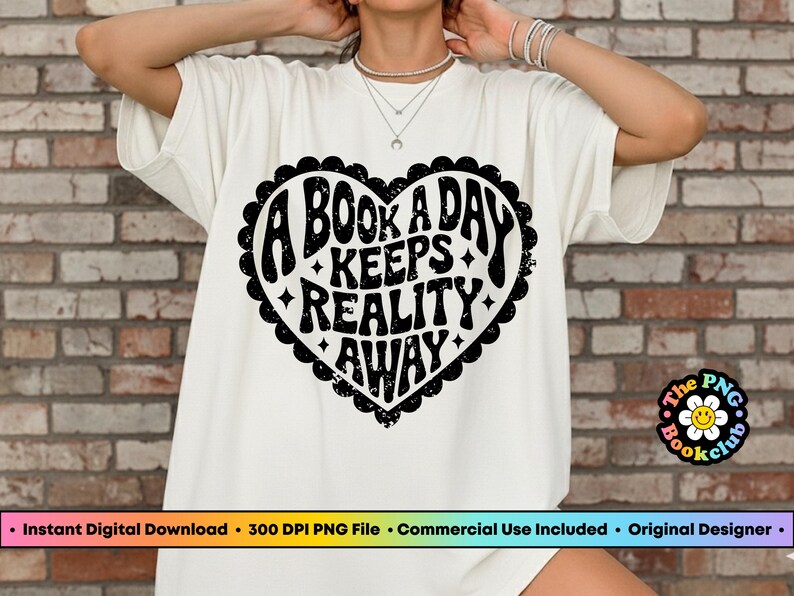 Pode incluir: Camiseta branca com um desenho de cora&ccedil;&atilde;o preto que diz "A BOOK A DAY KEEPS REALITY AWAY" em uma fonte retr&ocirc;. A camiseta tem gola redonda e mangas curtas. O logotipo PNG Bookclub &eacute; vis&iacute;vel.