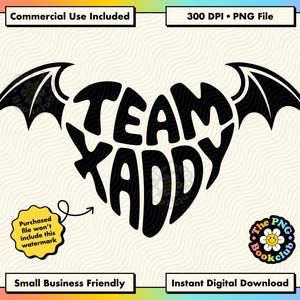 May include: A black graphic design featuring the text TEAM KADDY arranged in the shape of a heart with bat wings extending from the sides. The design is set against a cream-coloured background with wavy lines and includes a small circular logo.