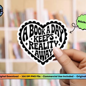 Pode incluir: Um autocolante em forma de cora&ccedil;&atilde;o com o texto "A BOOK A DAY KEEPS REALITY AWAY" em preto e branco. O autocolante tem uma borda ondulada e &eacute; segurado por uma pessoa. Um autocolante verde que diz "Stickers" tamb&eacute;m est&aacute; na imagem.