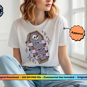 May include: White t-shirt with a coffin graphic. The coffin has a skull with a pink bow and the words "Didn't Finish Her TBR" on a banner. The shirt is part of the apparel category.