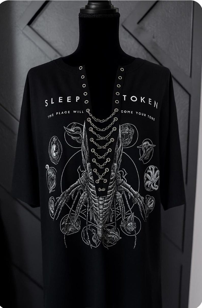 May include: Black t-shirt with a unique graphic design featuring a central skeletal figure with intricate details and surrounding circular illustrations. The text "SLEEP TOKEN" and "COME YOUR TONE" are printed on the shirt.