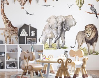 Puede incluir: Un conjunto de muebles infantiles con una mesa redonda y cuatro sillas de respaldos curvos sobre una alfombra redonda. La pared detrás muestra vinilos decorativos de acuarela con una jirafa, un elefante, un león, globos aerostáticos y aves.