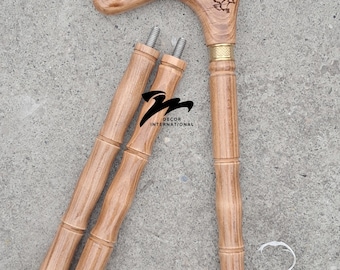 May include: A wooden walking cane with a carved handle featuring a bird design and decorative swirls. The cane has a bamboo-like shaft and a black rubber tip. The cane is partially disassembled, with two additional shaft pieces.