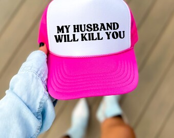 Peut inclure: Casquette de camionneur rose vif avec un panneau avant blanc. Le texte "MY HUSBAND WILL KILL YOU" est imprimé en noir. La casquette a une visière incurvée et un dos en filet.