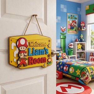 May include: A yellow rectangular wooden door sign hanging by a brown rope. The sign features a pixelated Mario character, a red mushroom, and the text Welcome Liam's Room in blue and red raised lettering, accented with small yellow star icons.