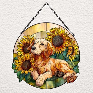 以下が含まれることがあります： ゴールデンレトリバーの犬とヒマワリを描いた丸いステンドグラス。犬は薄茶色で、ヒマワリは黄色と茶色の中心です。黒いチェーンで吊り下げられており、インテリアの装飾に適しています。