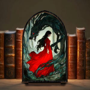May include: A framed illustration depicts a woman in a flowing red dress, facing a dark, menacing creature with glowing red eyes. The artwork is set against a backdrop of a forest, with a row of antique books in the background. The overall theme is fantasy and gothic.