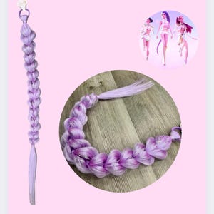 May include: A lavender reusable ponytail braid with a silver accent. The text "Rumi - Reusable ponytail" is at the top. The image also includes a circular inset showing the braid in a different position and a graphic of three figures.