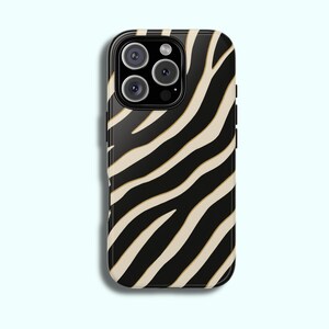 May include: A black and tan zebra print phone case. The case has a glossy finish and features a pattern of black stripes against a tan background. The phone case has a camera module with multiple lenses.