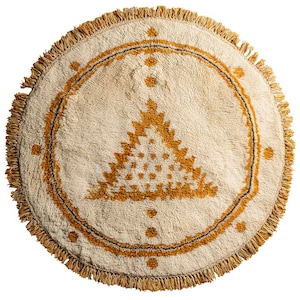 May include: Round, cream-colored rug with a geometric design in shades of gold and a black outline. The rug has a fringed edge and a central triangle pattern. The design includes small, dotted accents. The rug is suitable for a living room or bedroom.