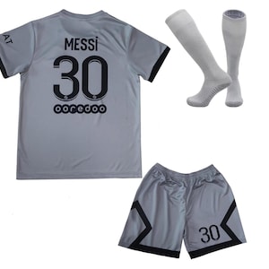 May include: A gray soccer uniform set featuring a jersey with "MESSI 30" and "ooredoo" printed on the back, matching shorts with the number 30, and a pair of gray socks. The jersey and shorts have black trim.
