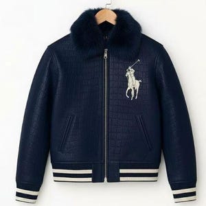 Könnte beinhalten: Marineblaue Bomberjacke mit Kunstfellkragen und weißem Polo-Spieler-Logo. Die Jacke hat ein strukturiertes Muster, einen Reißverschluss und weiße Streifen an den Manschetten und am Saum.