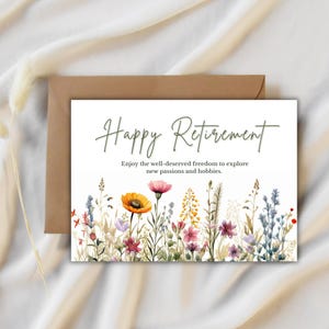 May include: A greeting card with the words "Happy Retirement" in green script. The card features a watercolor illustration of colorful wildflowers. A brown envelope is behind the card.