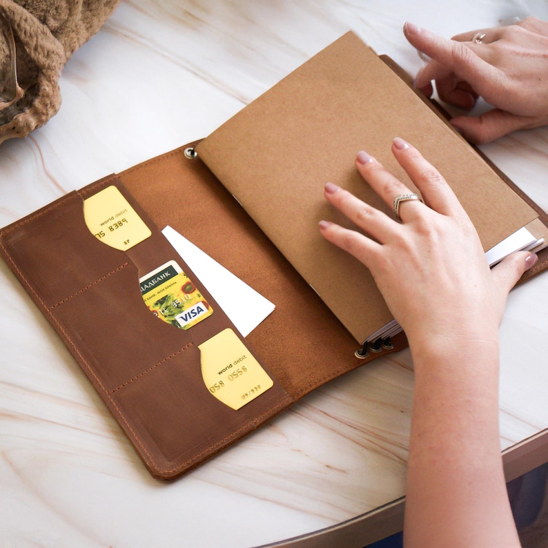 Handcrafted from premium leather, this refillable leather notebook cover features handy inner pockets, a wrap closure, and personalized monogram options. Ideal for journaling, work, or travel, it combines elegance with function. A perfect gift for writers, students, or professionals. Leather; Handmade. Add a personal touch to your daily notes today!