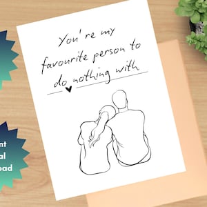 以下が含まれることがあります： 「You're my favourite person to do nothing with」のテキストと、カップルの白黒イラストが描かれた白いカード。カードは桃色の封筒の上にあり、背景には植物があります。