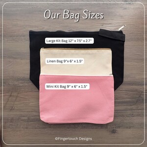 Może przedstawiać: Trzy prostokątne kosmetyczki z zamkiem błyskawicznym z napisem Our Bag Sizes. Czarna duża torba 30,48 x 19,05 x 6,86 cm, beżowa lniana torba 22,86 x 15,24 x 3,81 cm i r&oacute;żowa mini torba 22,86 x 15,24 x 3,81 cm od Fingertouch Designs.