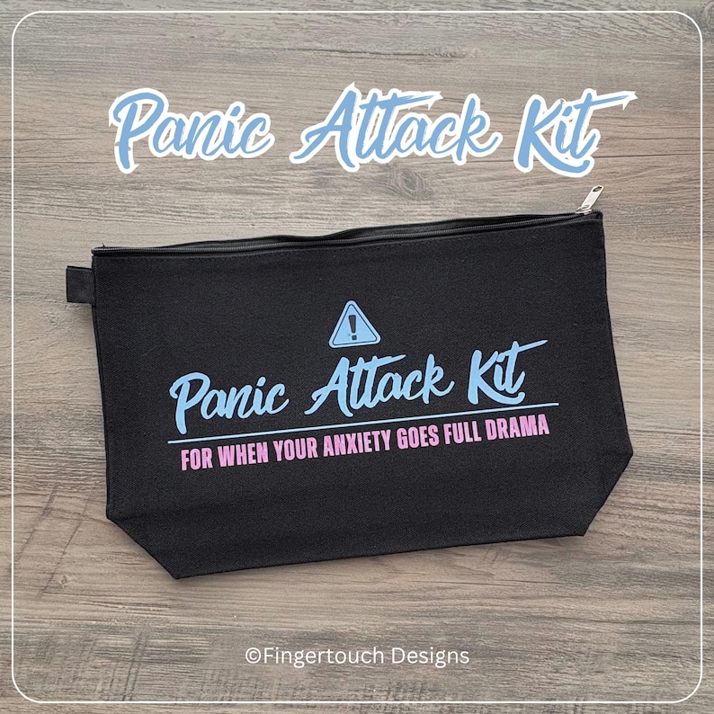Może przedstawiać: Czarna, prostokątna kosmetyczka zapinana na zamek z napisem Panic Attack Kit w kolorze jasnoniebieskim, tr&oacute;jkątną ikoną ostrzegawczą oraz napisem FOR WHEN YOUR ANXIETY GOES FULL DRAMA w kolorze r&oacute;żowym. Nazwa marki Fingertouch Designs jest nadrukowana na dole.