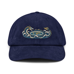 Könnte beinhalten: Eine marineblaue Baseballkappe aus Kord mit einer zentralen Grafik eines langen, schlangenförmigen Drachen, der eine flache, kreisförmige Weltkarte umschließt, umgeben von stilisierten blauen und weißen Meereswellen in Gold-, Blau- und Weißtönen.