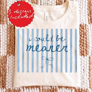 May include: Cream-colored t-shirt with blue vertical stripes and the phrase "i could be meaner" in blue script. A small blue bow is at the bottom. A red tag indicates "3 designs included".