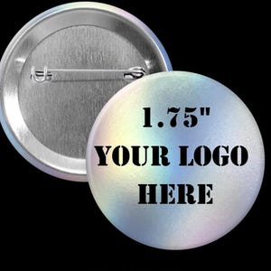 May include: A round button with a holographic finish, featuring the text "1.75" YOUR LOGO HERE". The button's back is silver with a pin. The button is 1.75 inches in diameter.