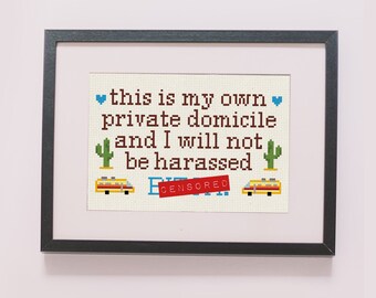 May include: A framed cross-stitch design with the text "this is my own private domicile and I will not be harassed" with a red rectangle that says "CENSORED" and two yellow buses with cacti on either side.