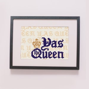 May include: A framed cross-stitch design with a gold crown and the text "Yas Queen" in blue.