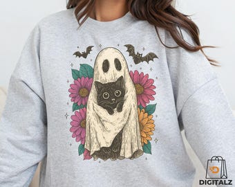May include: A light gray sweatshirt featuring a Halloween-themed graphic. The design includes a black cat wrapped in a ghost sheet, surrounded by pink and yellow flowers and bats. The text "Digital Download 300 DPI PNG file!" is at the bottom.