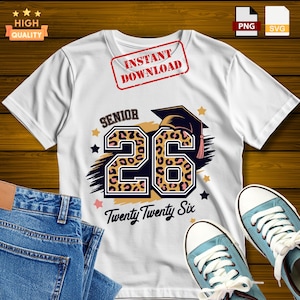 Puede incluir: Camiseta blanca con un diseño "Senior 26" con estampado de leopardo, gorro de graduación y el texto "Twenty Twenty Six". La camiseta se muestra con vaqueros azules y zapatillas.