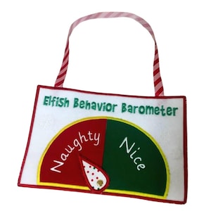May include: A white felt sign with a red and white striped hanging ribbon. The text reads Elfish Behavior Barometer. A semi-circular gauge features a red section labeled Naughty and a green section labeled Nice, with a movable white pointer.