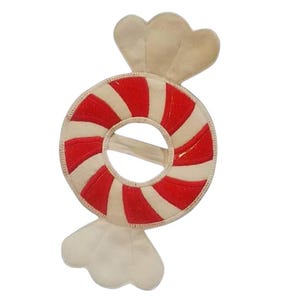 May include: A circular candy-shaped decoration featuring alternating red and cream-colored stripes. The center of the circular portion is hollow, and the top and bottom ends are shaped like the twisted wrappers of a piece of hard candy.