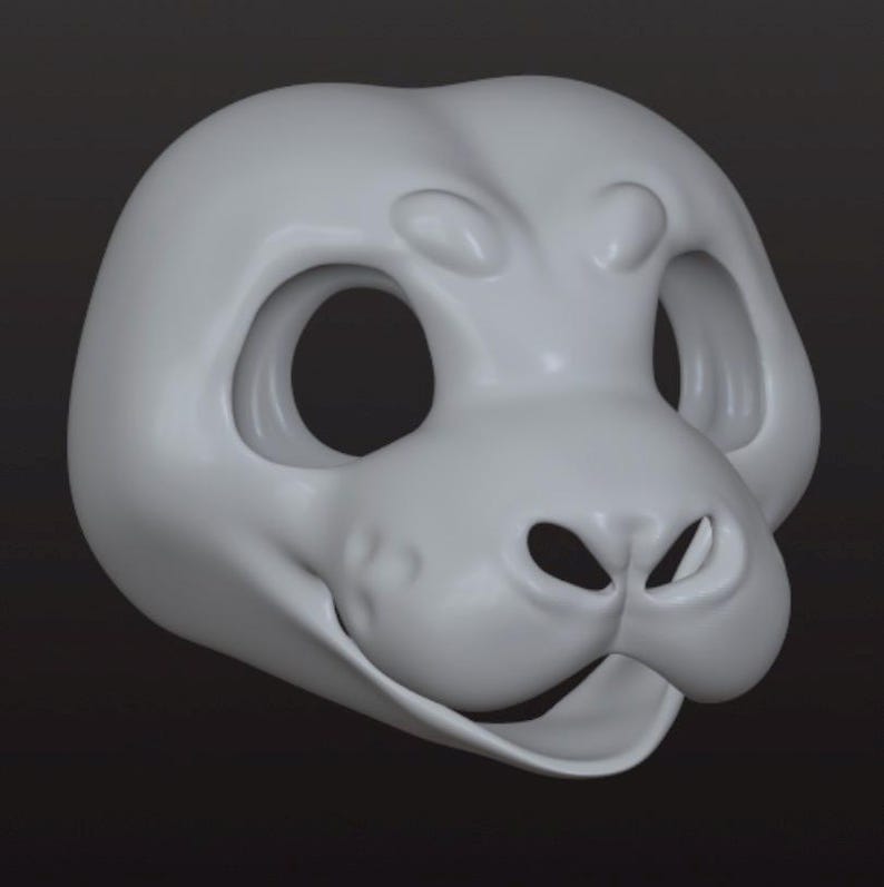 May include: A light gray, smooth, three-dimensional animal mask base featuring large, hollow eye sockets, a prominent snout with two nostril openings, and a wide, open mouth area. The surface is matte and uniform, showing a sculpted, rounded head shape.