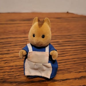 Puede incluir: Una taza de cer&aacute;mica blanca con asa negra y el texto "But First, Coffee" en negrita negra. La taza se encuentra sobre un fondo borroso, resaltando su dise&ntilde;o limpio.