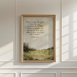 Może przedstawiać: Oprawiony wydruk w złotej ramie. Wydruk zawiera cytat z Jeremiasza 29:11, na tle akwarelowego krajobrazu pola z drzewami i kwiatami. Cytat brzmi: „Bo Ja wiem, jakie myśli myślę o was..."