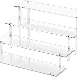 May include: Clear acrylic display stand with four tiered shelves. The shelves are rectangular and supported by clear cylindrical posts. The stand is designed to showcase items and products.