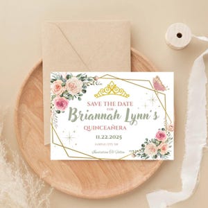 May include: A quinceañera invitation card with floral and gold geometric design. The card features the text "Save the Date for Briannah Lynn's Quinceañera" with the date 11.22.2025. The card is on a wooden tray with an envelope.