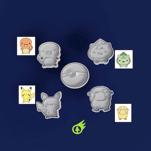 May include: A collection of gray cookie cutters in the shapes of various Pokémon characters, including Pikachu, Charmander, and Bulbasaur, along with a Poké Ball. The cutters are arranged on a dark blue background.